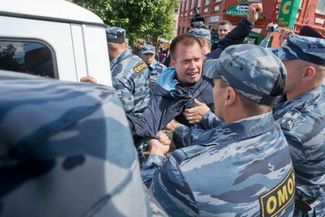 Сотрудники ОМОНа задерживают сторонника Навального Николая Ляскина, который возглавлял шествие протестующих по центру Кирова.