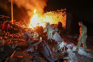 Жители Степанакерта тушат пожар, возникший после обстрела города. 23 октября 2020 года